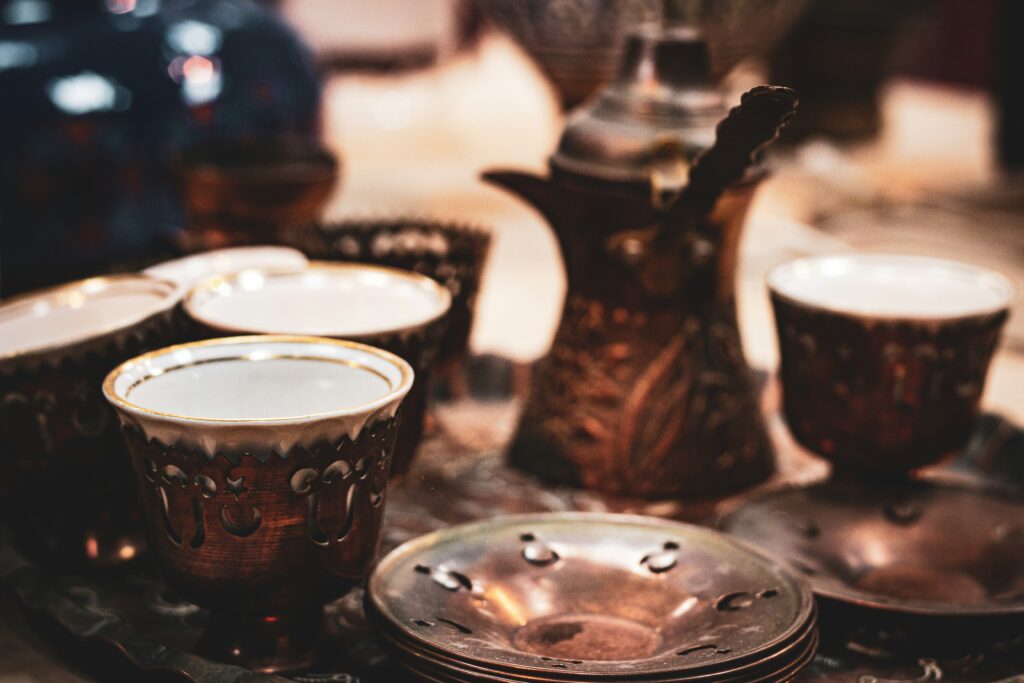 Traditionelle bosnische Kaffeetassen mit Kupferkanne (Fildžan und Džezva), warmes Licht